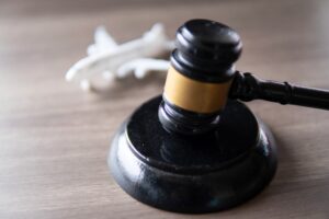 Closeup image of judge gavel and toy plane on table.