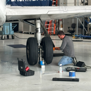 Mechanic repairing landing gear on aircraft