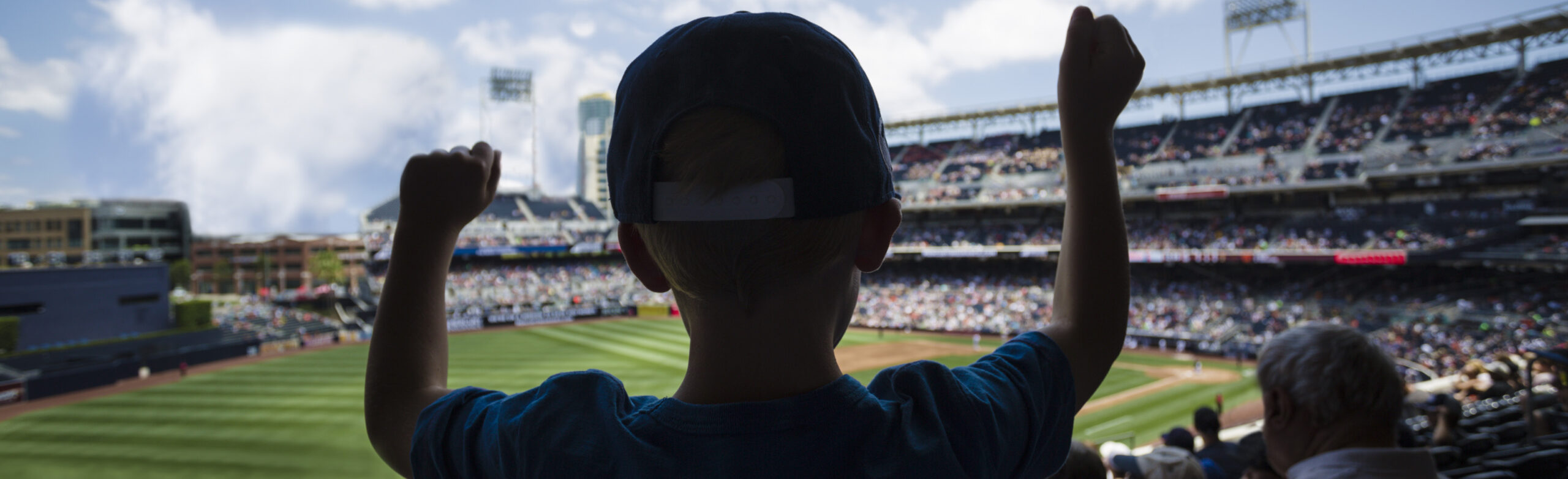 kid standing up cheering at baseball stadium during world series