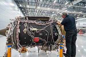 close up of aircraft mechanic performing maintenance on aircraft engine