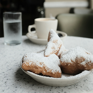 Beignets and coffee on table at Cafe Beignet in New Orleans