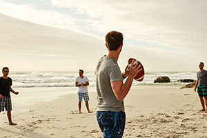 Individuals playing football on beach in Bahamas