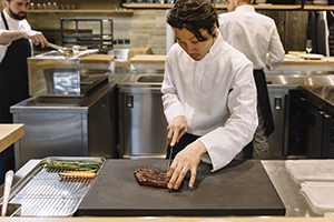 Chef preparing steak in restaurant