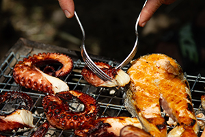 Professional chef preparing various seafood including octopus and fish