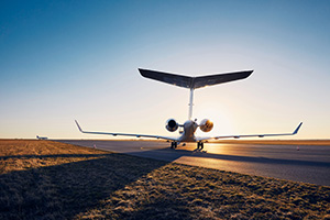 Silhouette of private jet against runway at airport