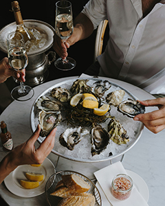 Fresh oysters served with white wine in Miami restaurant