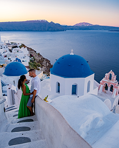 Young couple watching the sunrise in Santorini Greece