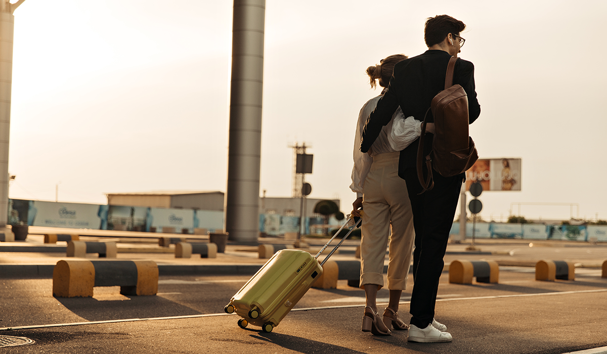 Young couple at airport embarking on romantic Valentine's Day getaway by private jet