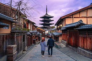 Young traveling couple looking at Yasaka Pagoda and Hokan-ji Temple in Kyoto, Japan